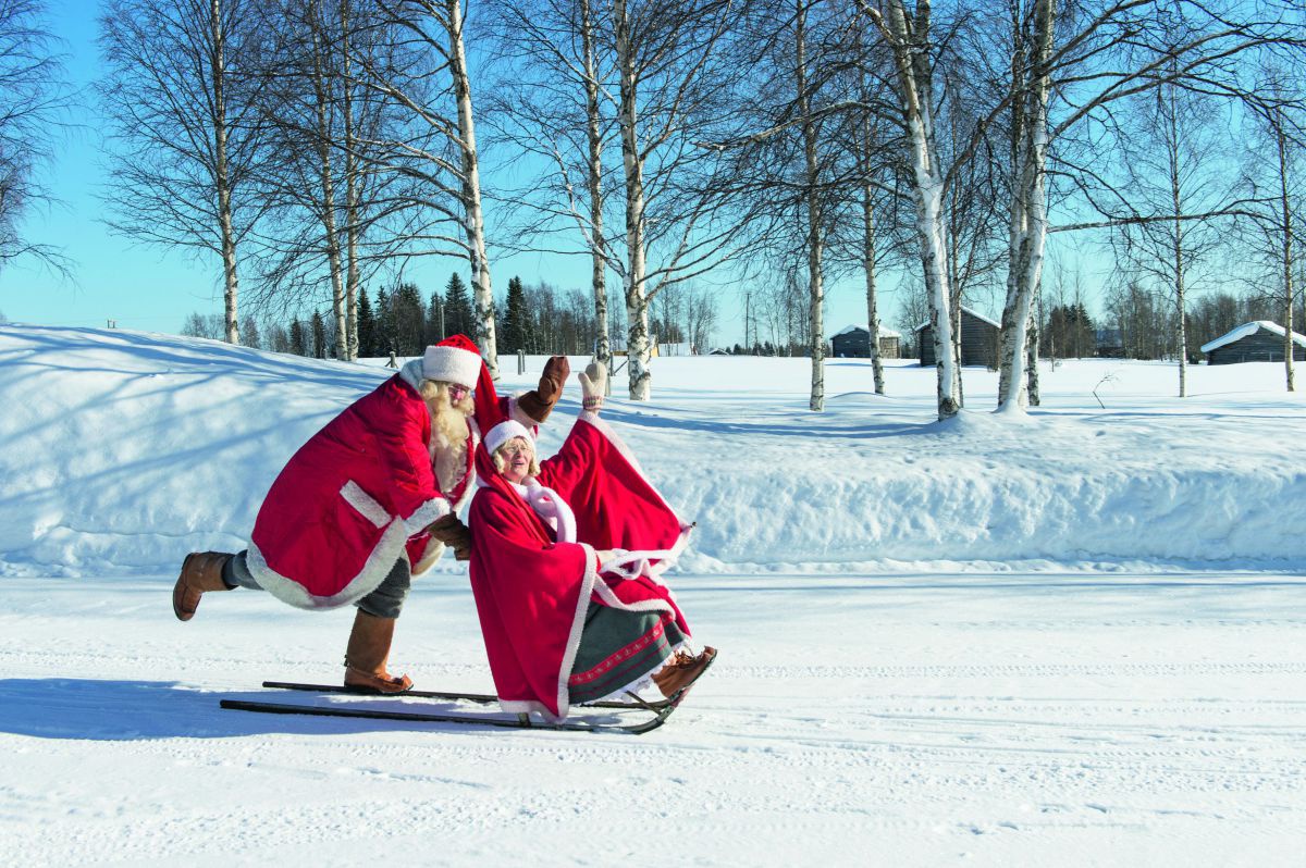 In einer verschneiten Winterlandschaft läuft ein als Weihnachtsmann verkleideter Mann über einen zugefrorenen, mit Schnee bedeckten See und schiebt dabei einen Schlitten vor sich her, auf dem eine Frau - ebenfalls in Weihnachtsmannkostüm - sitzt. Beide he