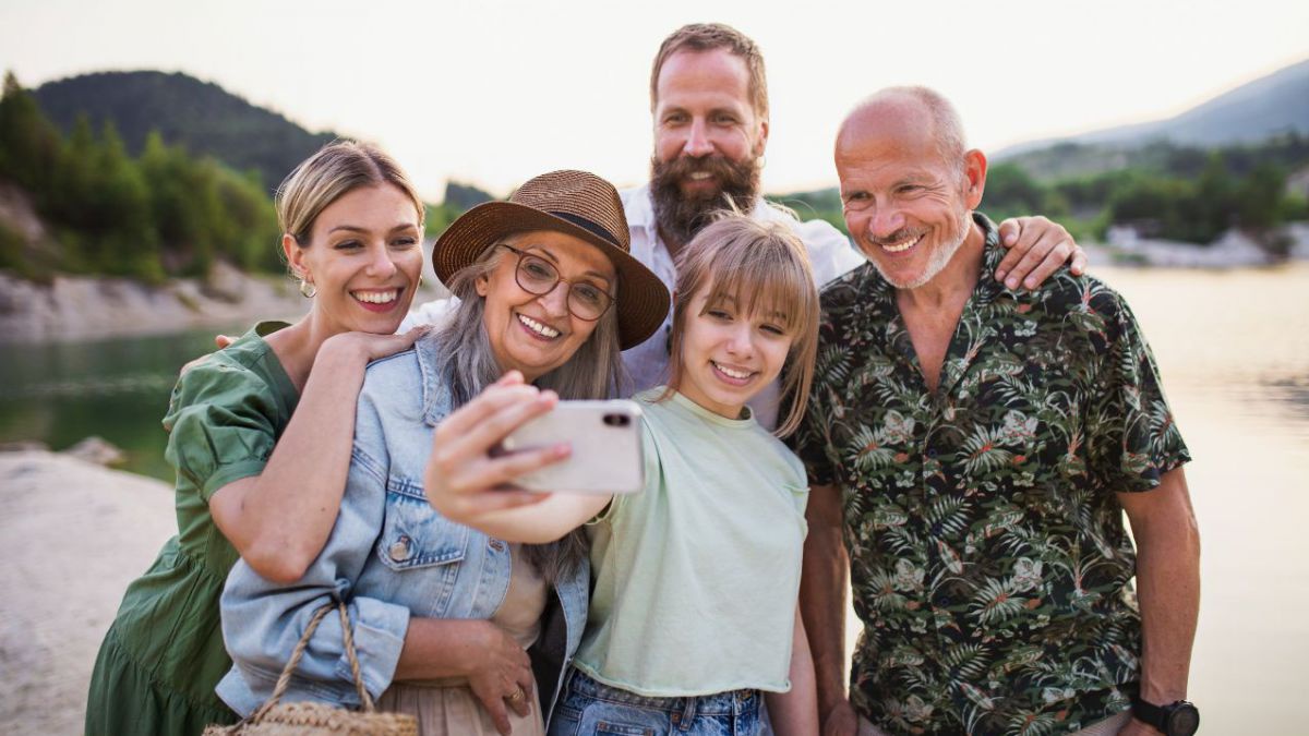 Gruppe von Personen aus unterschiedlichen Generationen macht ein Selfie.