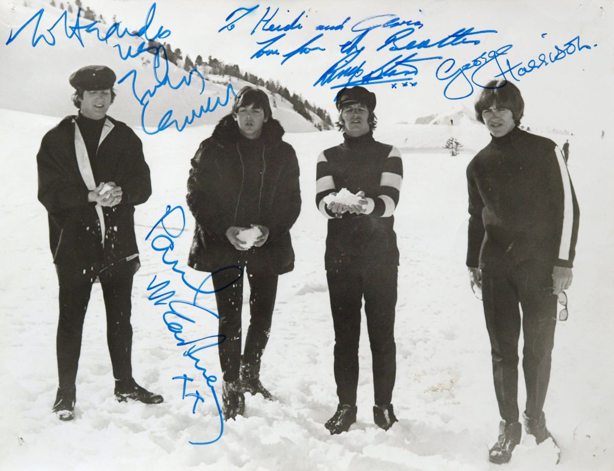 Schwarz-weiß-Foto der Beatles mit Autogrammen, drei der vier haben Schneebälle in der Hand.