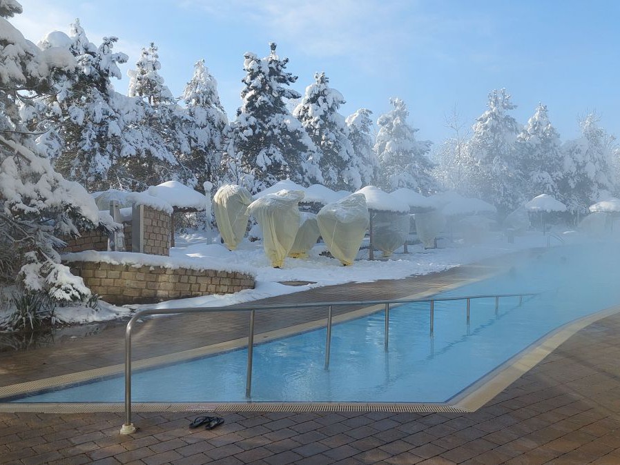 Aussenbecken in der Therme Geinberg, Landschaft ist tief verschneit.